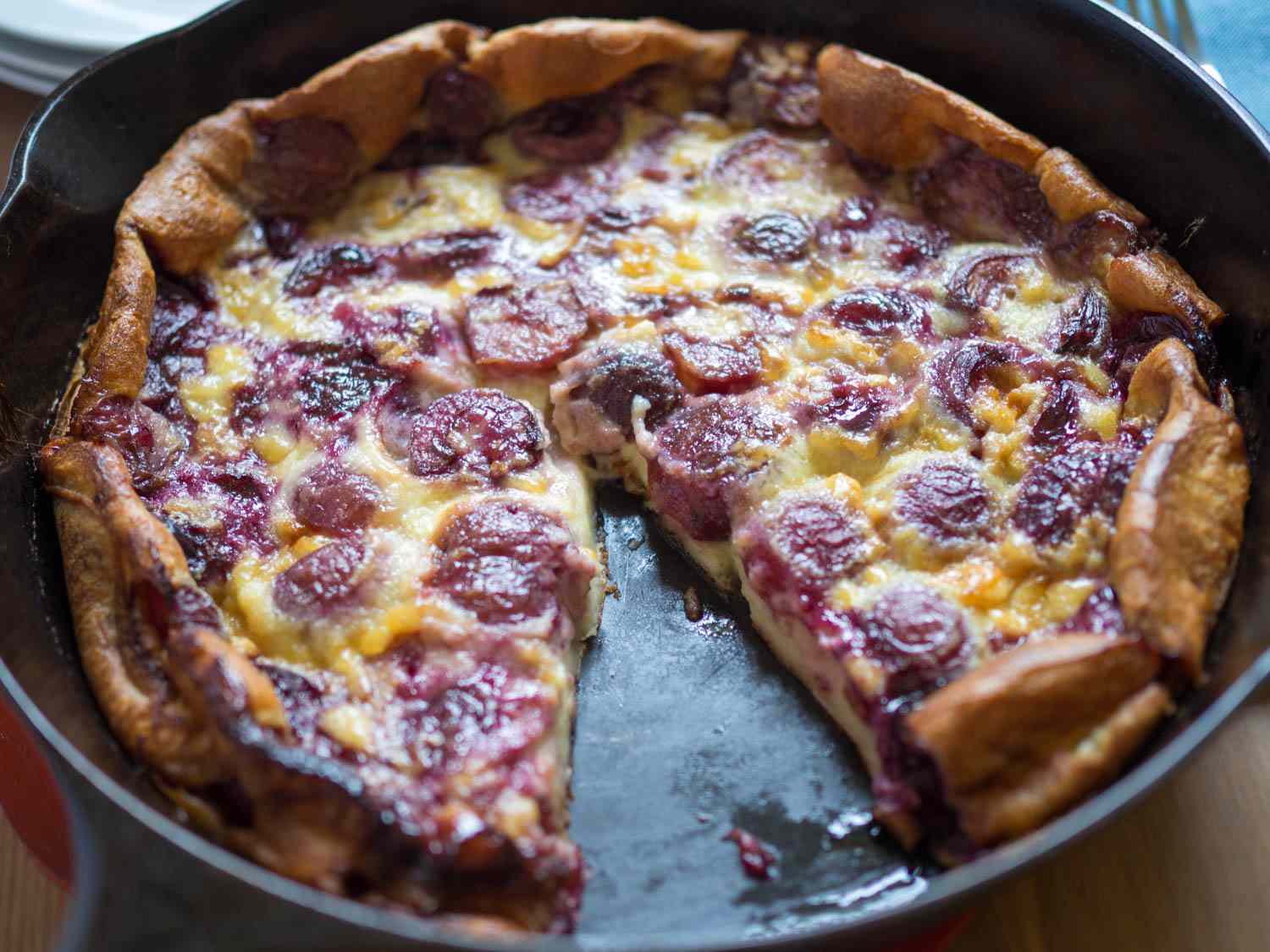 Baked cherry clafoutis with a slice removed.