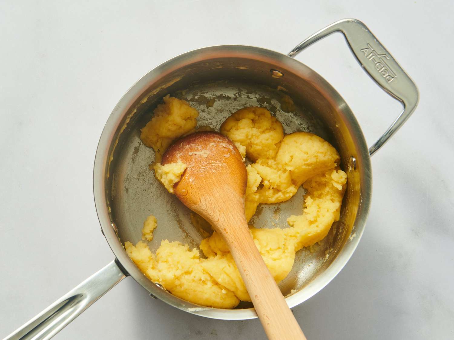 Making choux pastry in a saucepan.