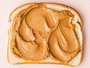 Slice of bread with peanut butter spread evenly