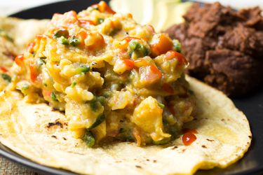 A plate of Tex-Mex migas next to beans.