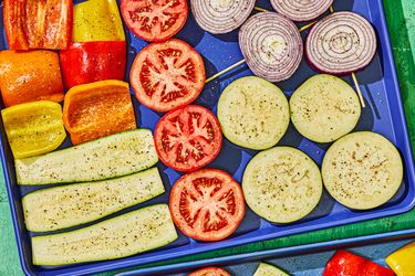 Assorted vegetables sliced and seasoned, arranged on a tray for cooking