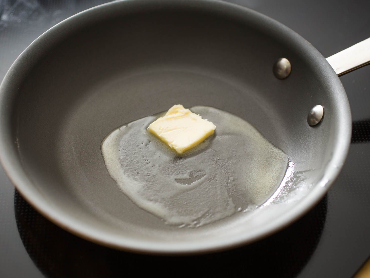 Butter melting in a non-stick skillet.