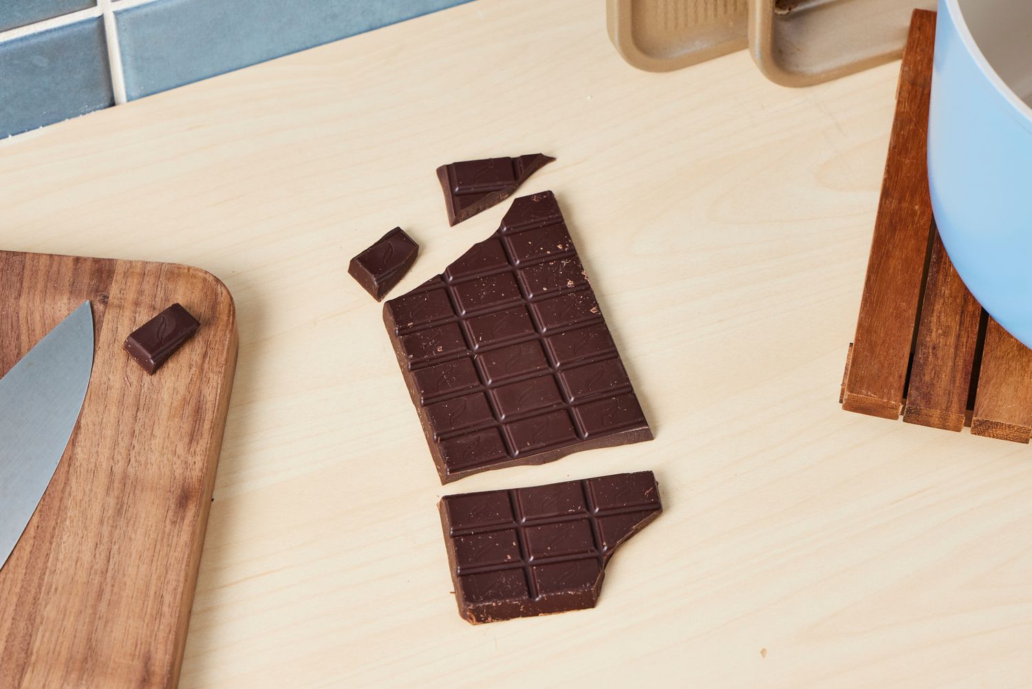 An unwrapped dark chocolate bar on a kitchen countertop.