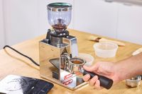 Coffee grounds filling a portafilter from the Lelit Fred Tempo Burr Grinder