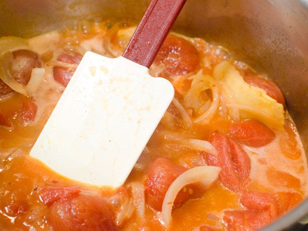 Whole tomatoes, onion, butter, chiles, garlic, ginger, and spices simmering for butter chicken sauce