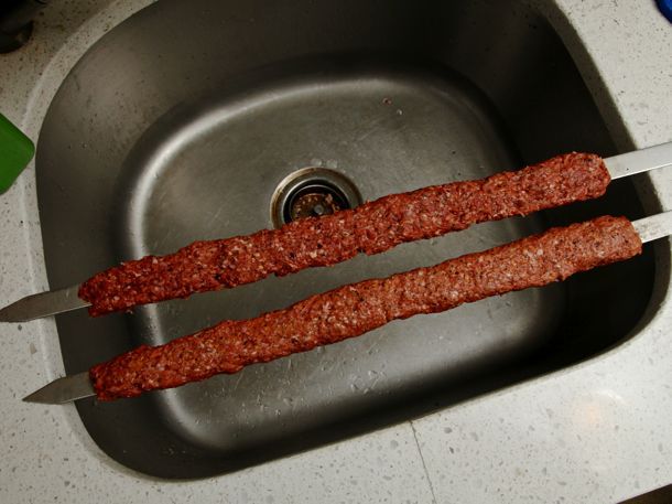 Overhead shot of author's kitchen sink. Two Adana kebab skewers have been laid across the sink.