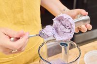 A person spoons puree from the head of the Breville Control Grip Immersion Blender