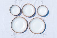 Set of Lulu & Georgia Tara Melamine Dinnerware Set bowls and plates arranged on a patterned tablecloth