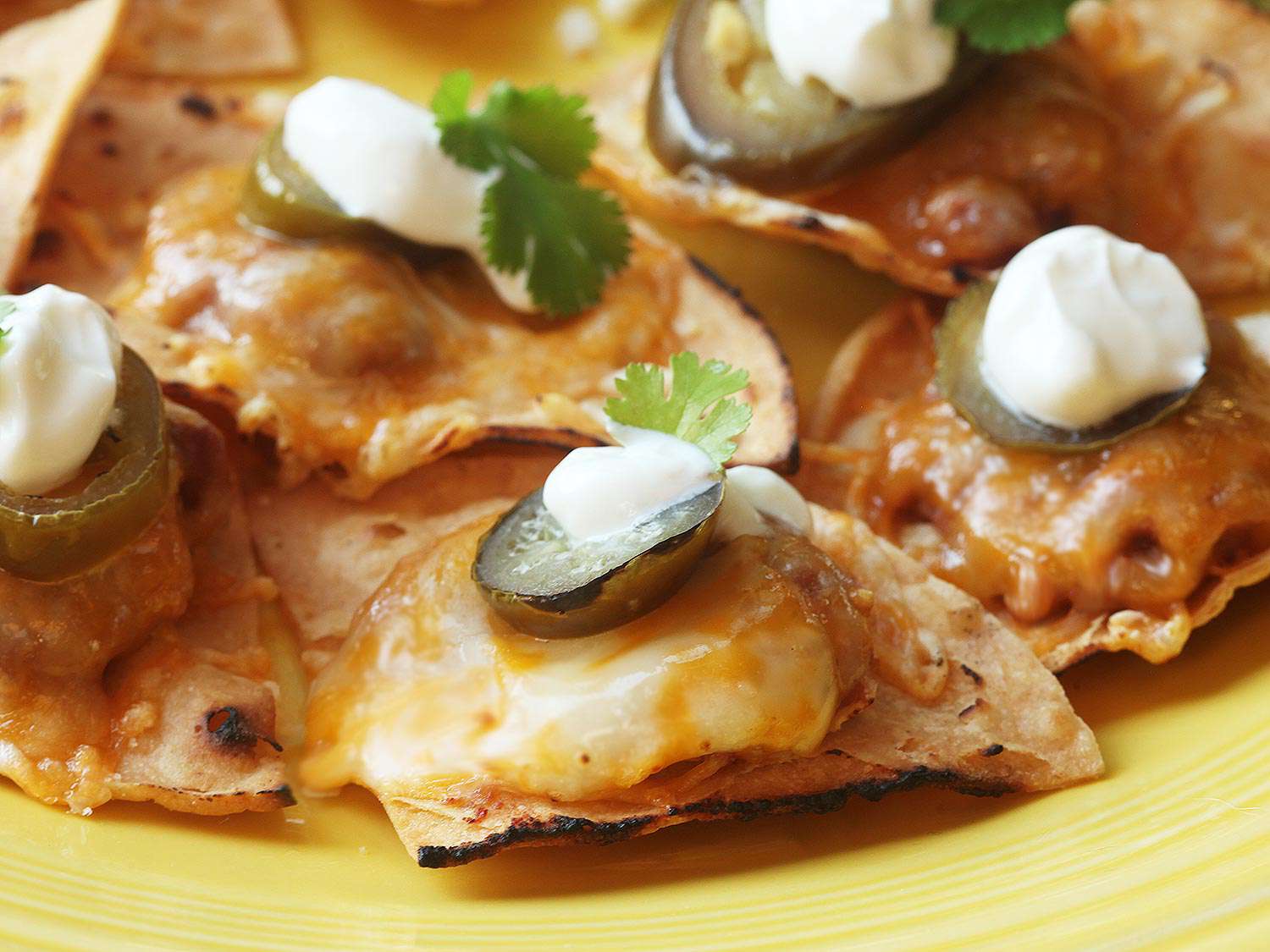 Closeup of cheesy nachos made with homemade tortilla chips.
