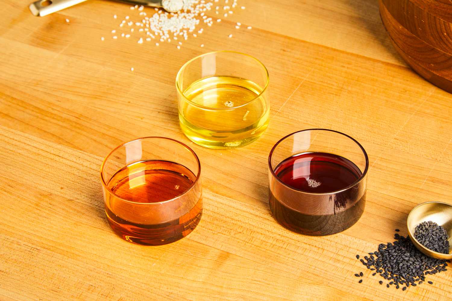 three glass bowls filled with different colored sesame oil