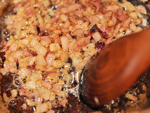 Sauteing chopped onion in rendered bacon fat.