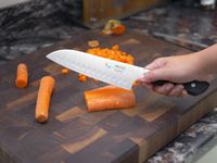 a person holding the mac hollow edge santoku