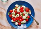 Marinated mozzarella, cherry tomato, and basil salad inside a dish