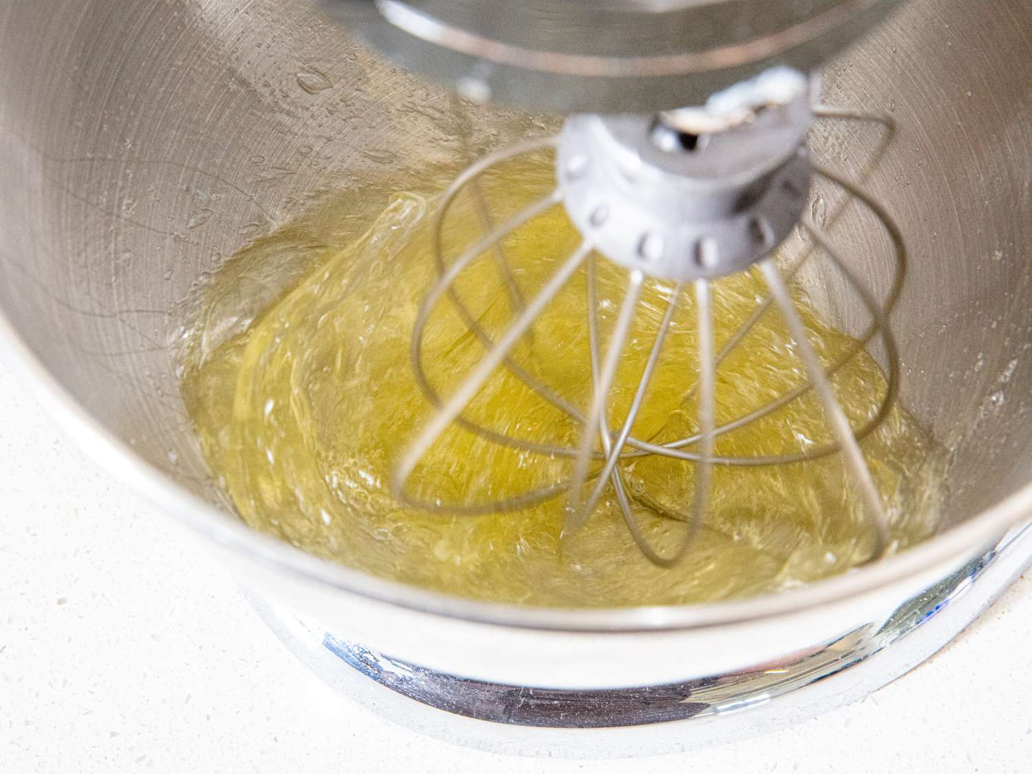 Whisking egg whites in the bowl of a stand mixer.