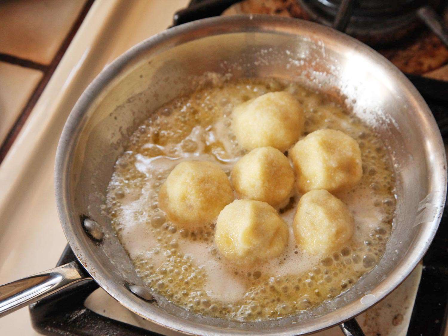 Gnudi cooking in a butter sauce. 