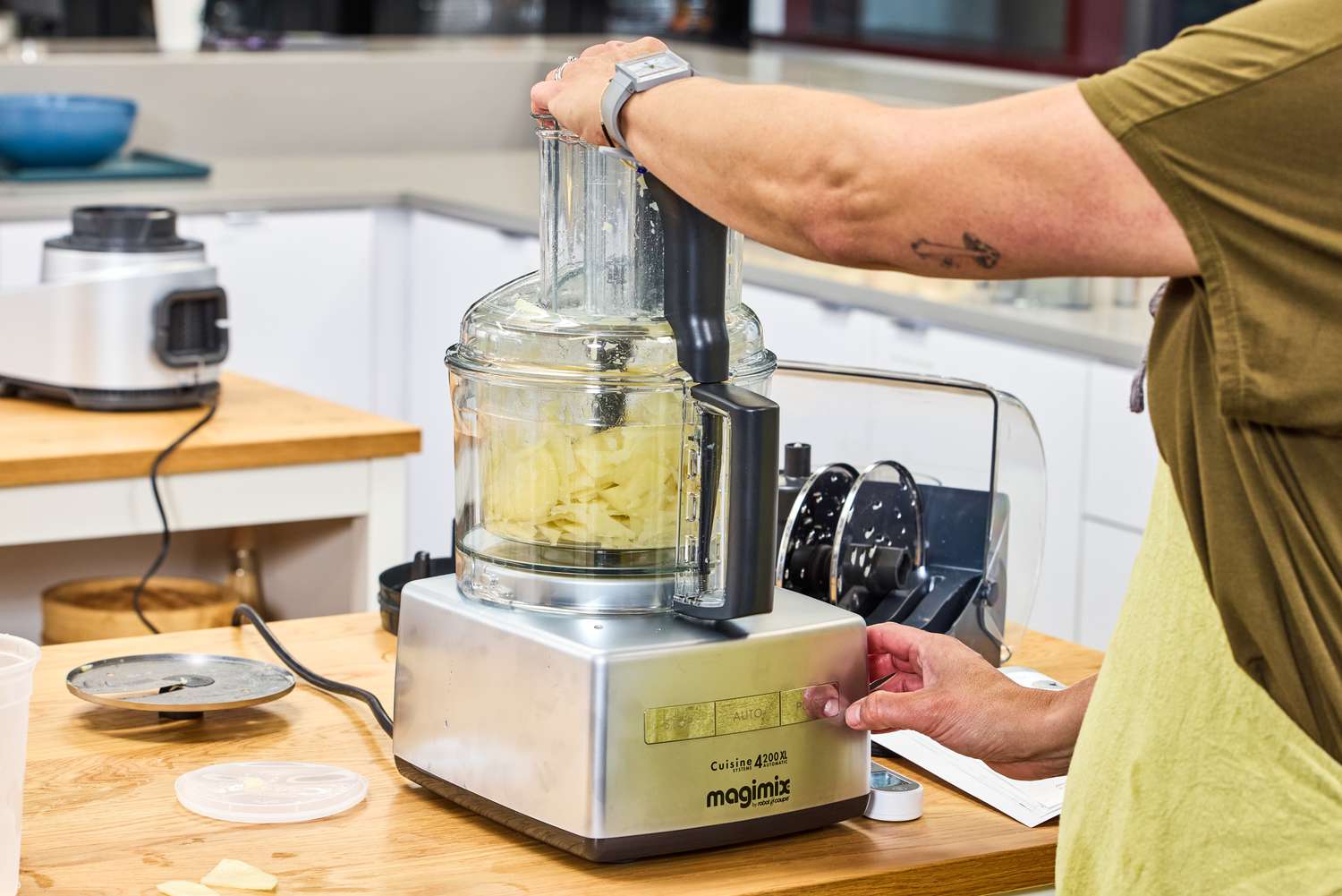 A person uses the Magimix 14-Cup Food Processor