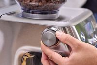 A person turns a dial on the Breville The Barista Pro Espresso Machine