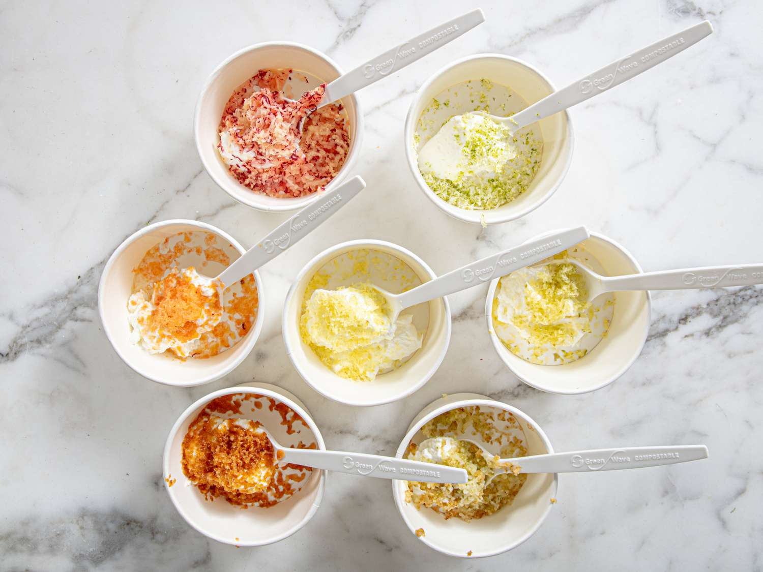 Grated Frozen Fruits Sprinkled Over Containers of Yogurt