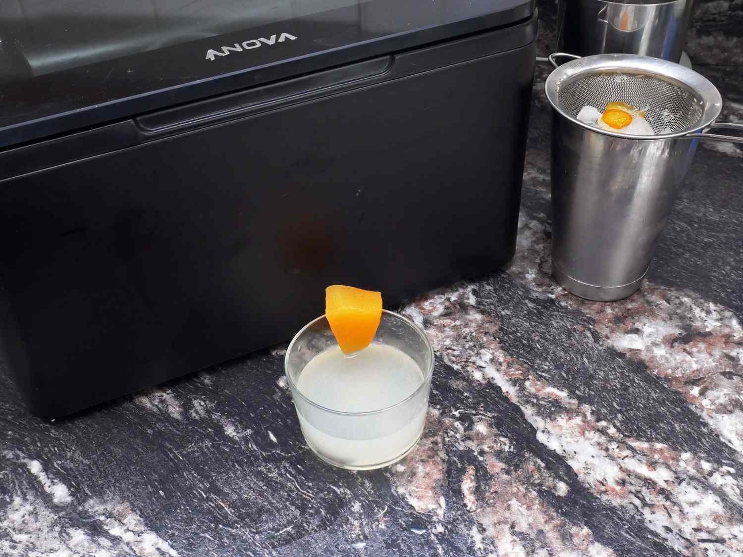 cocktail with infused cucumber cantaloupe gin in front of the anova chamber sealer