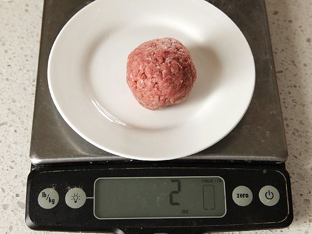 Ball of ground beef on a plate on a digital scale