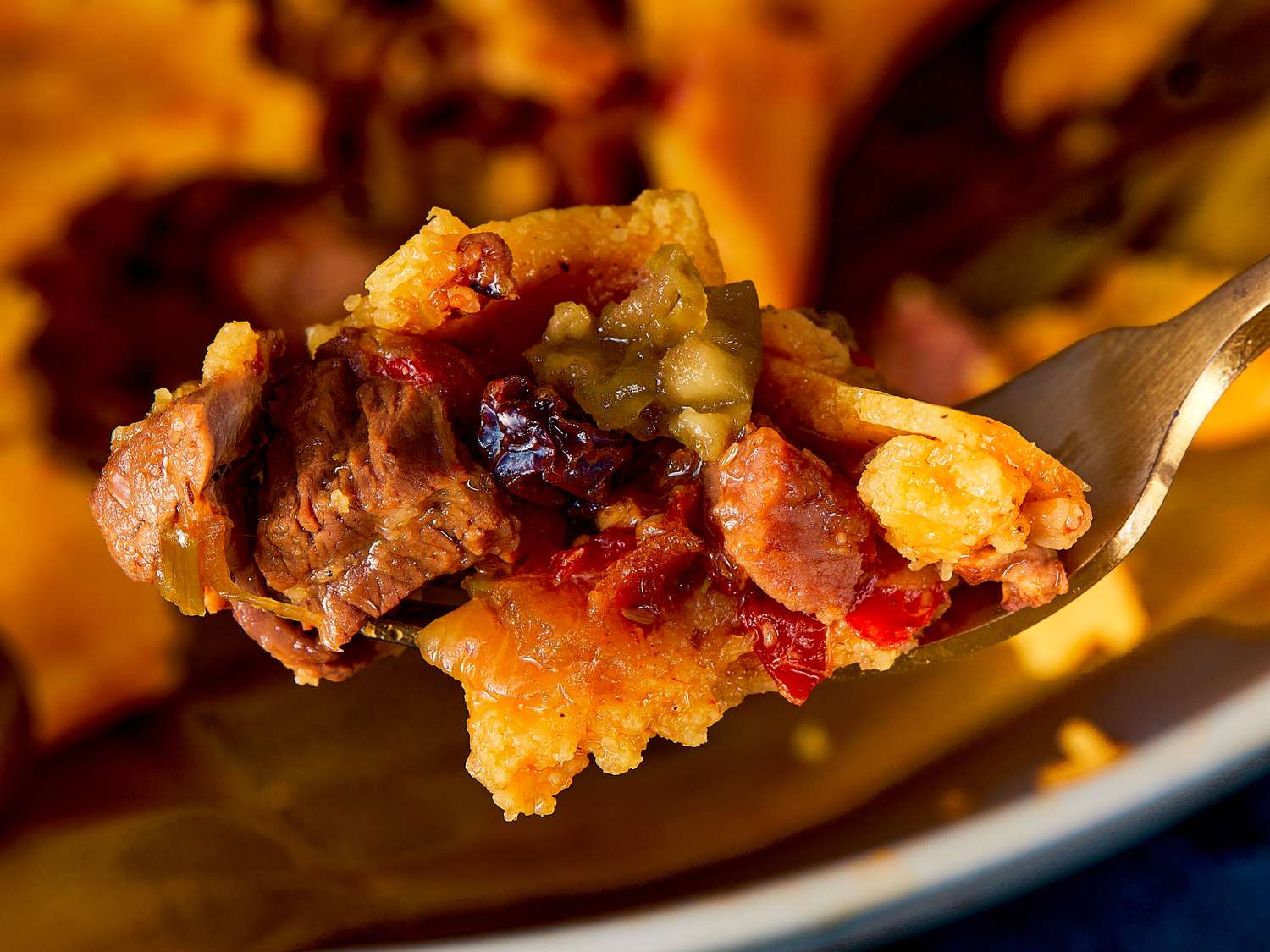 A fork holding a portion of hallaca showing meat and other fillings