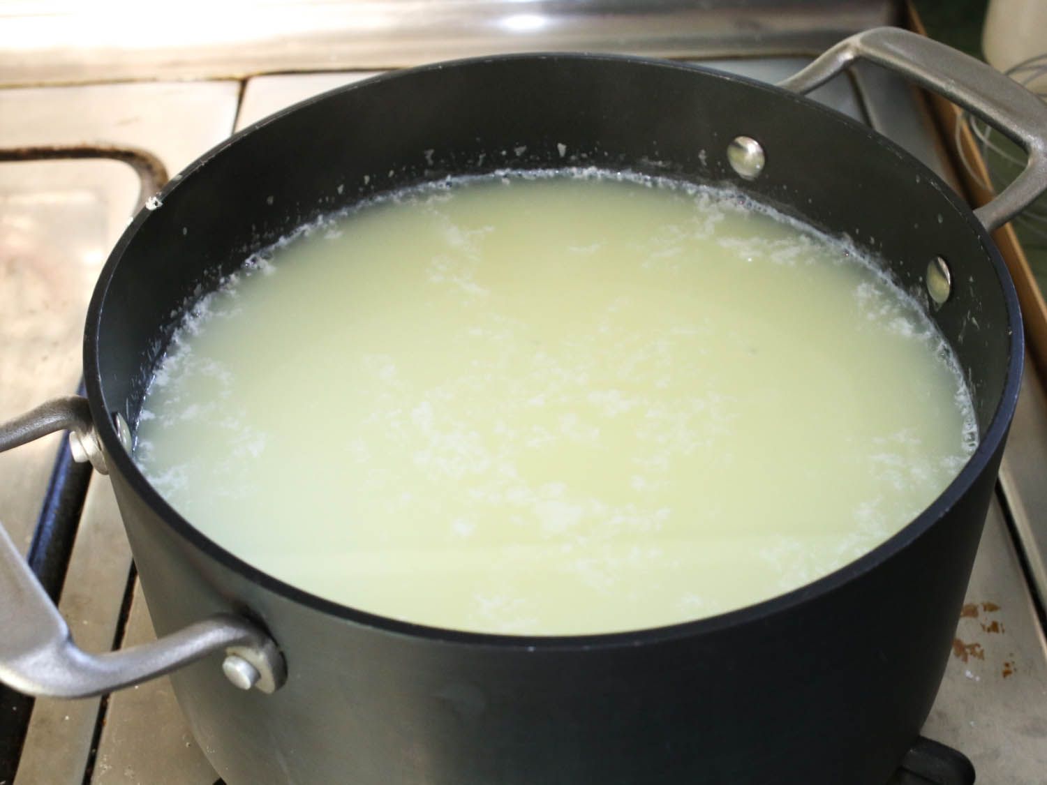 A pot of curds and whey heating on the stove.