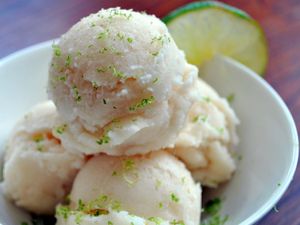 Closeup of three scoops of Ginger Beer, Rum, and Coconut Sorbet in a snall bowl. Lime zest has been sprinkled over the sorbet.