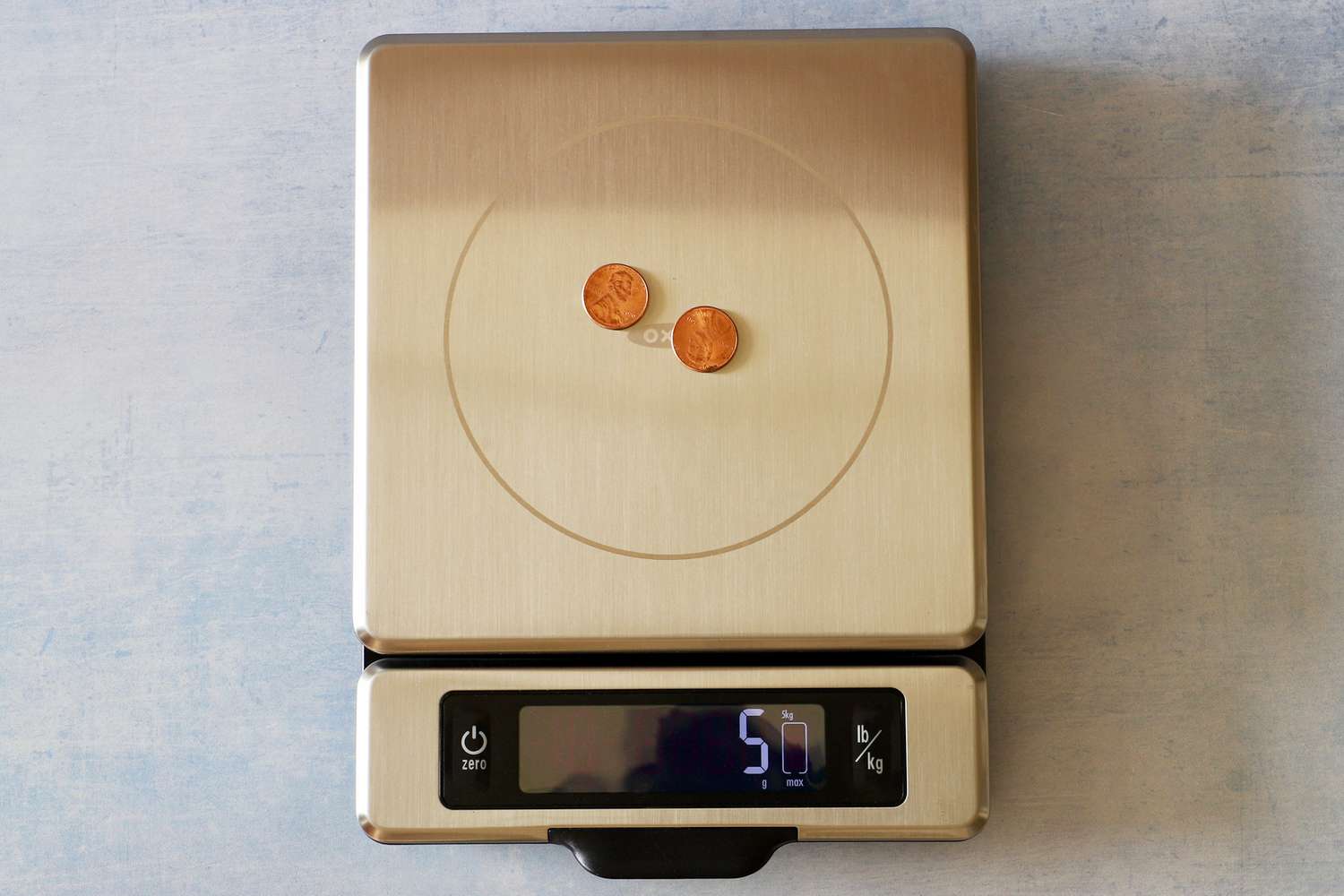 A kitchen scale with two pennies on its platform