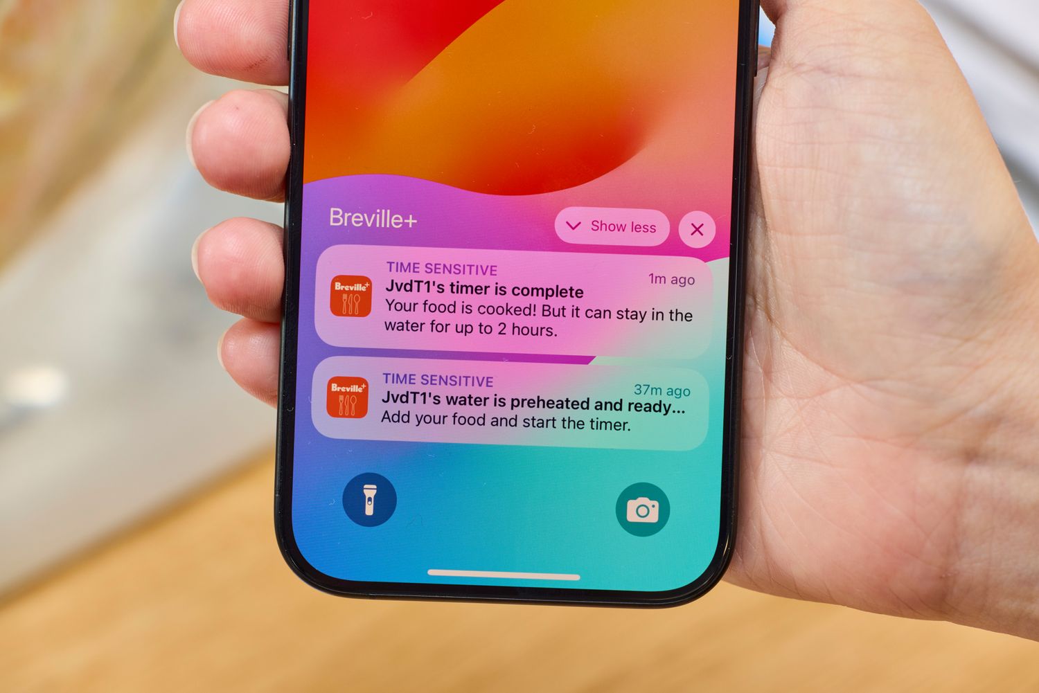 A person holding a phone showing Breville+ notifications related to cooking progress for the Breville Joule Turbo Sous Vide Machine