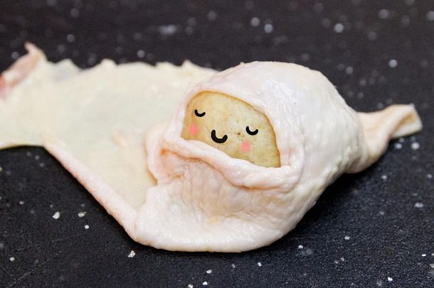 A matzo ball snugly cloaked in chicken skin, with a superimposed expression of contentment on its matzo 