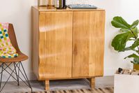 A wooden cabinet with drinks and glasses on top, a chair and a plant next to it