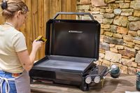A person takes the temperature on the Weber Slate 22 inch Rust-Resistant Tabletop Griddle