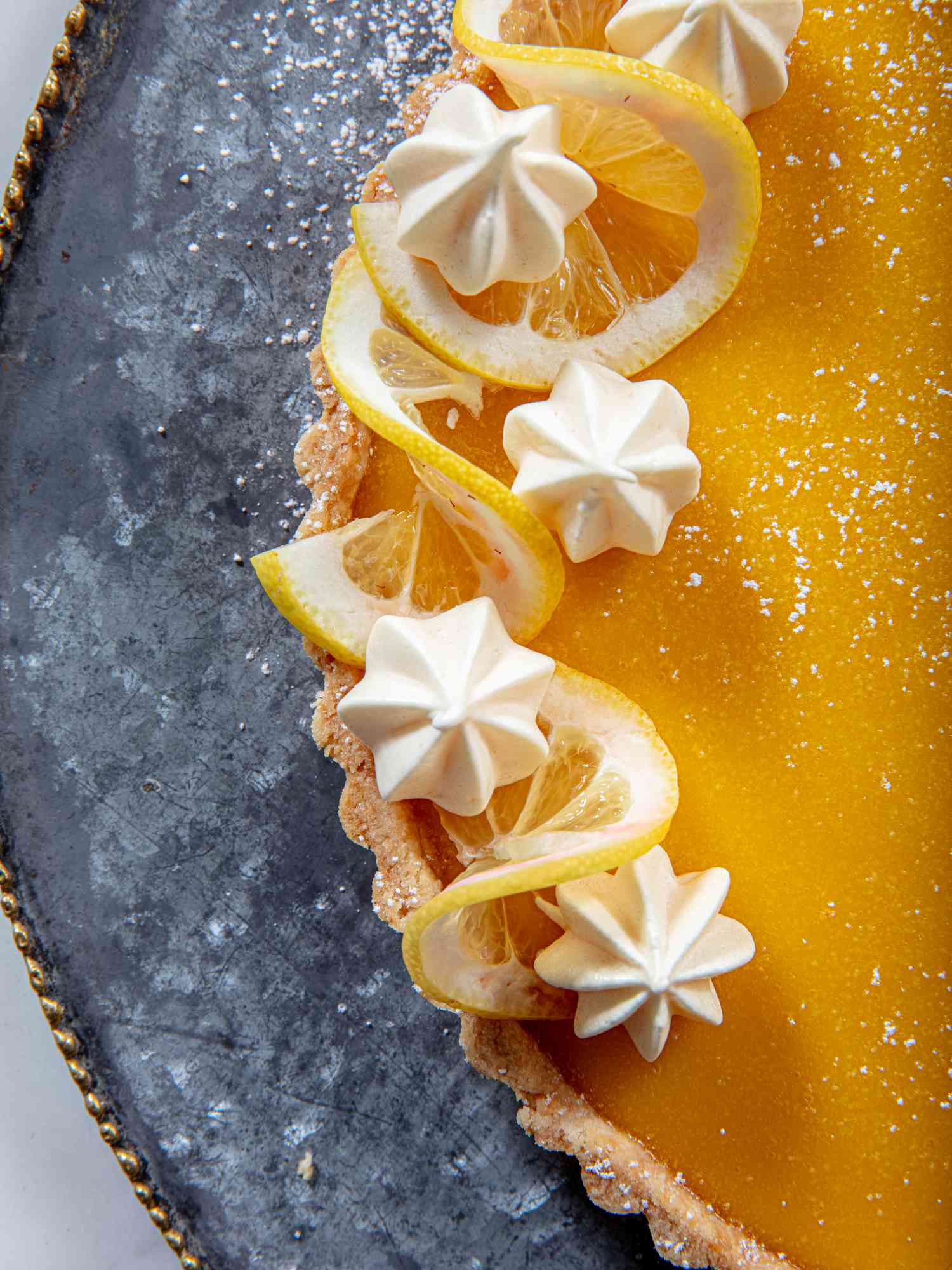 Meringues and lemon slices on a lemon tart.