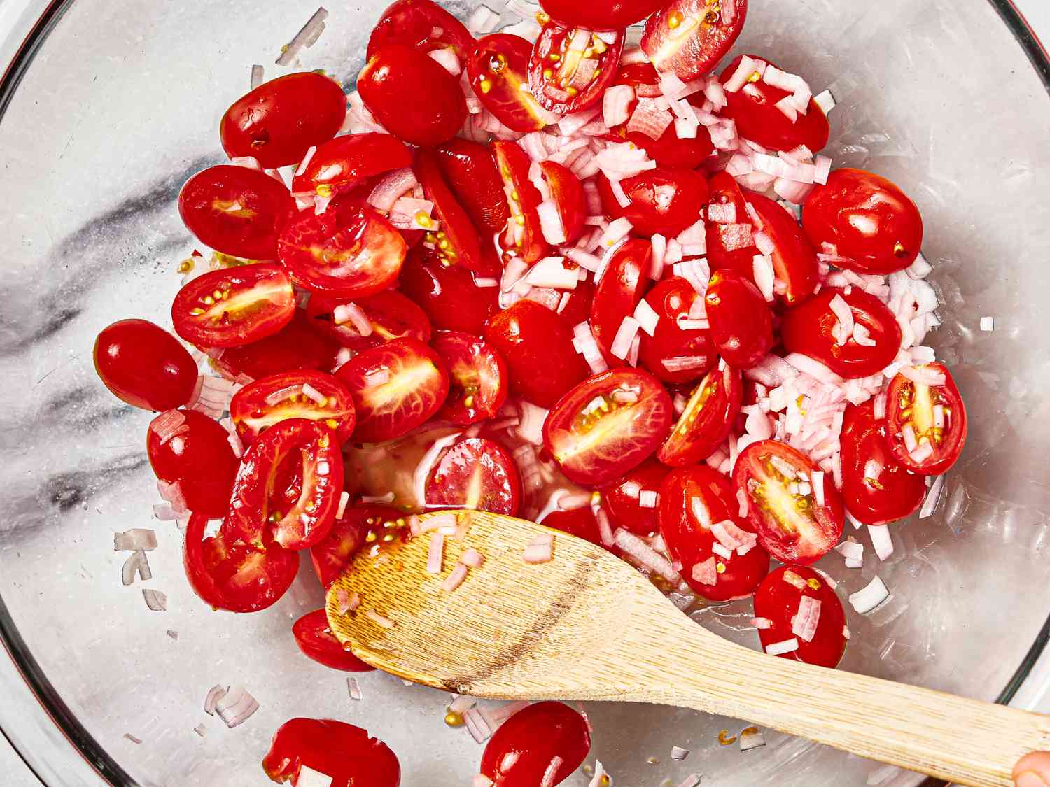 Overhead view of tomatoes and onions in a glass bowl 