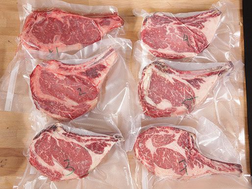 Six shrink-wrapped steaks that have been dry aged for varying periods of time.