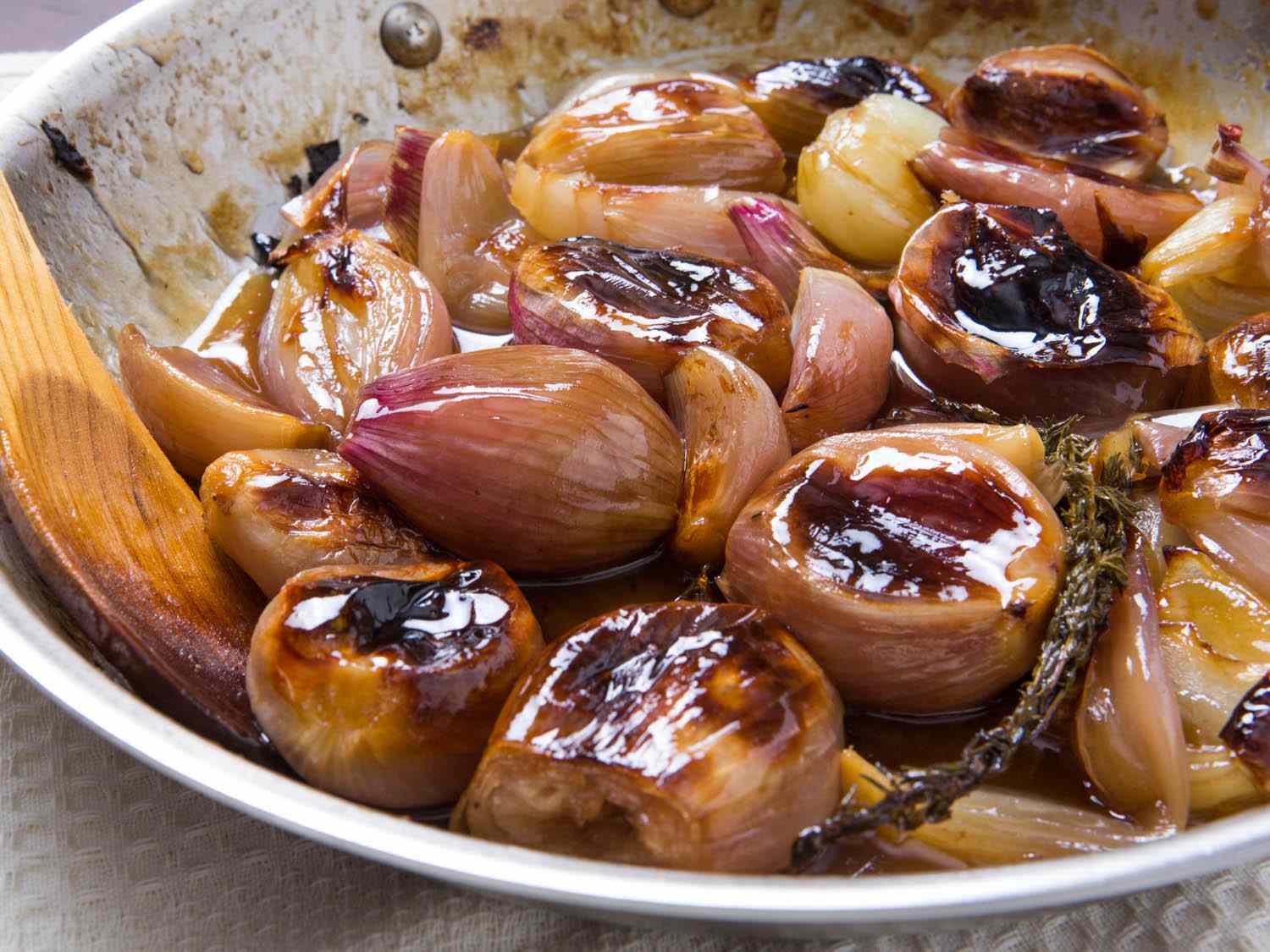 Close up view of caramelized pan-roasted tender shallots.