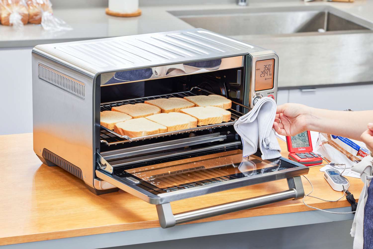 A hand placing toast into the Breville the Smart Oven Air Fryer