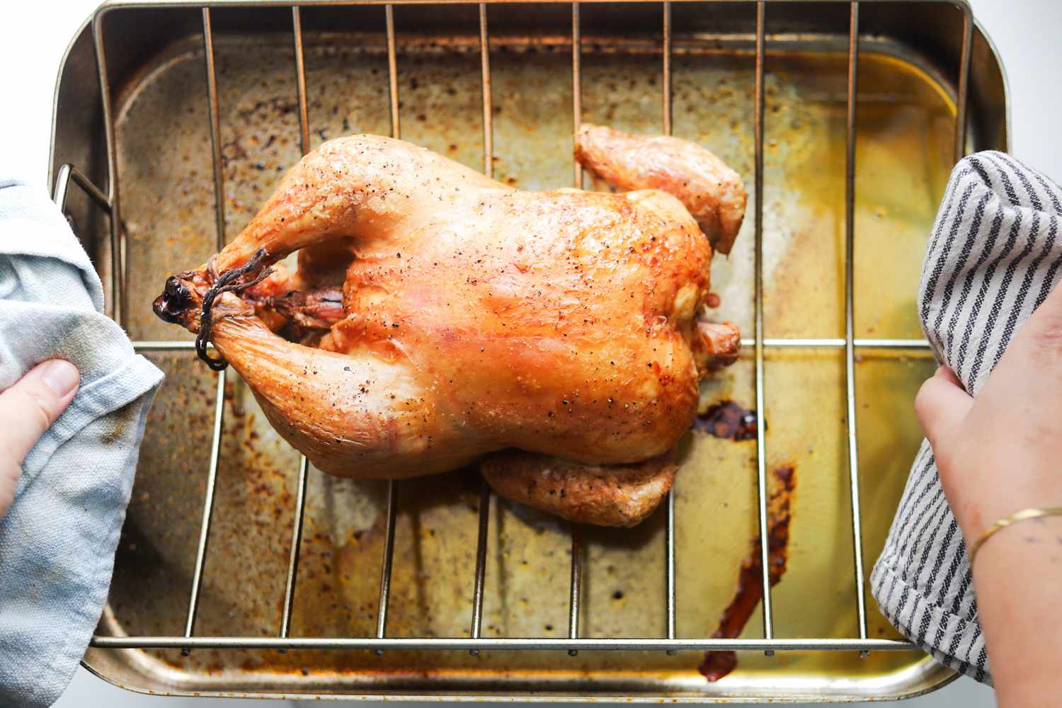 A person picking up a roasting pan.
