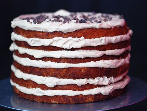 Profile view of coconut and espresso cream layer cake, perched on a cake stand.