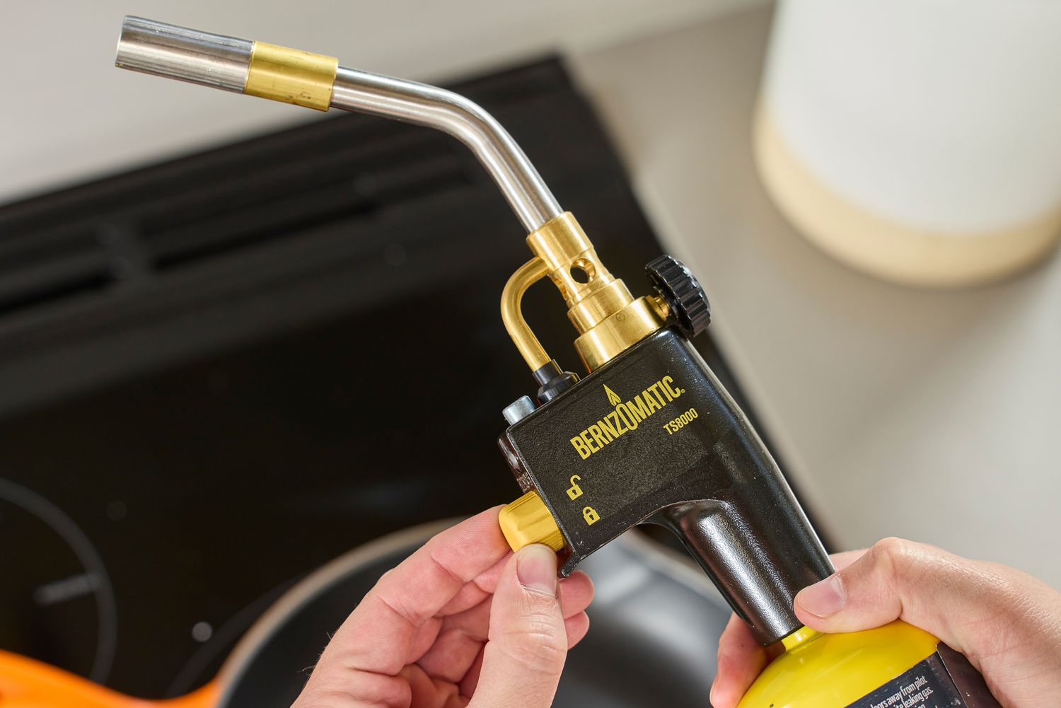 someone adjusting the safety lock on the bernzomatic 