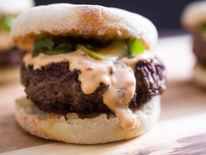 Closeup of a Sichuan Peppercorn Burger With Chile-Ginger Mayo and Cucumber Pickles.