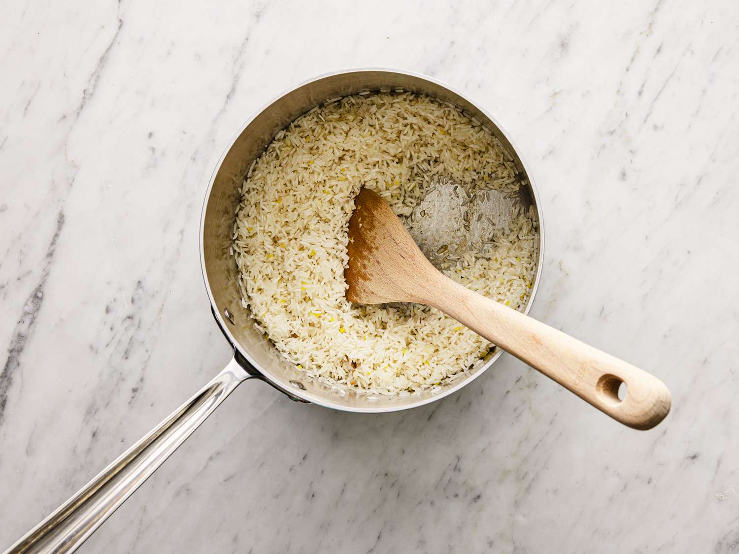 Overhead view of a wooden spoon in the rice