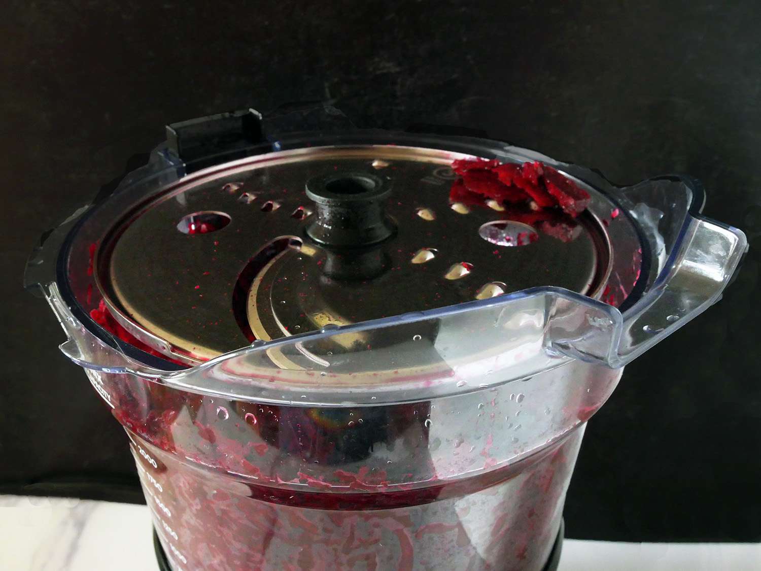 a closeup shot of the food processor with the shred disk after shredding beets.