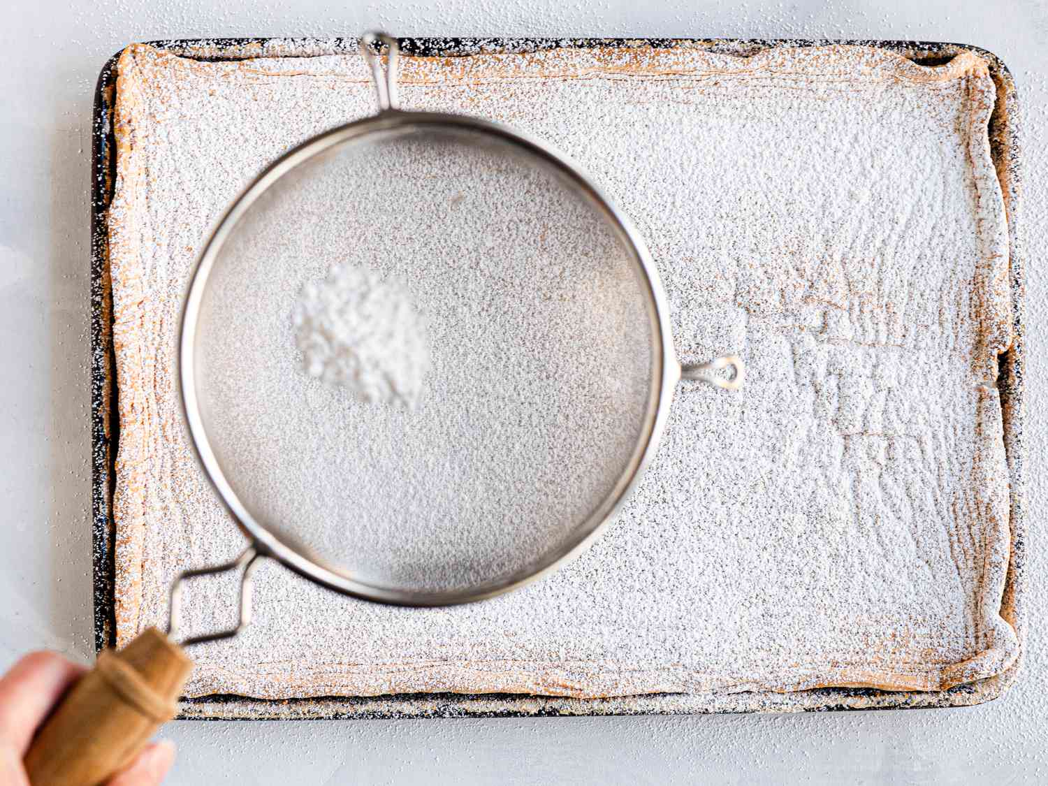 Overhead view of dusting egg meringue with sugar 