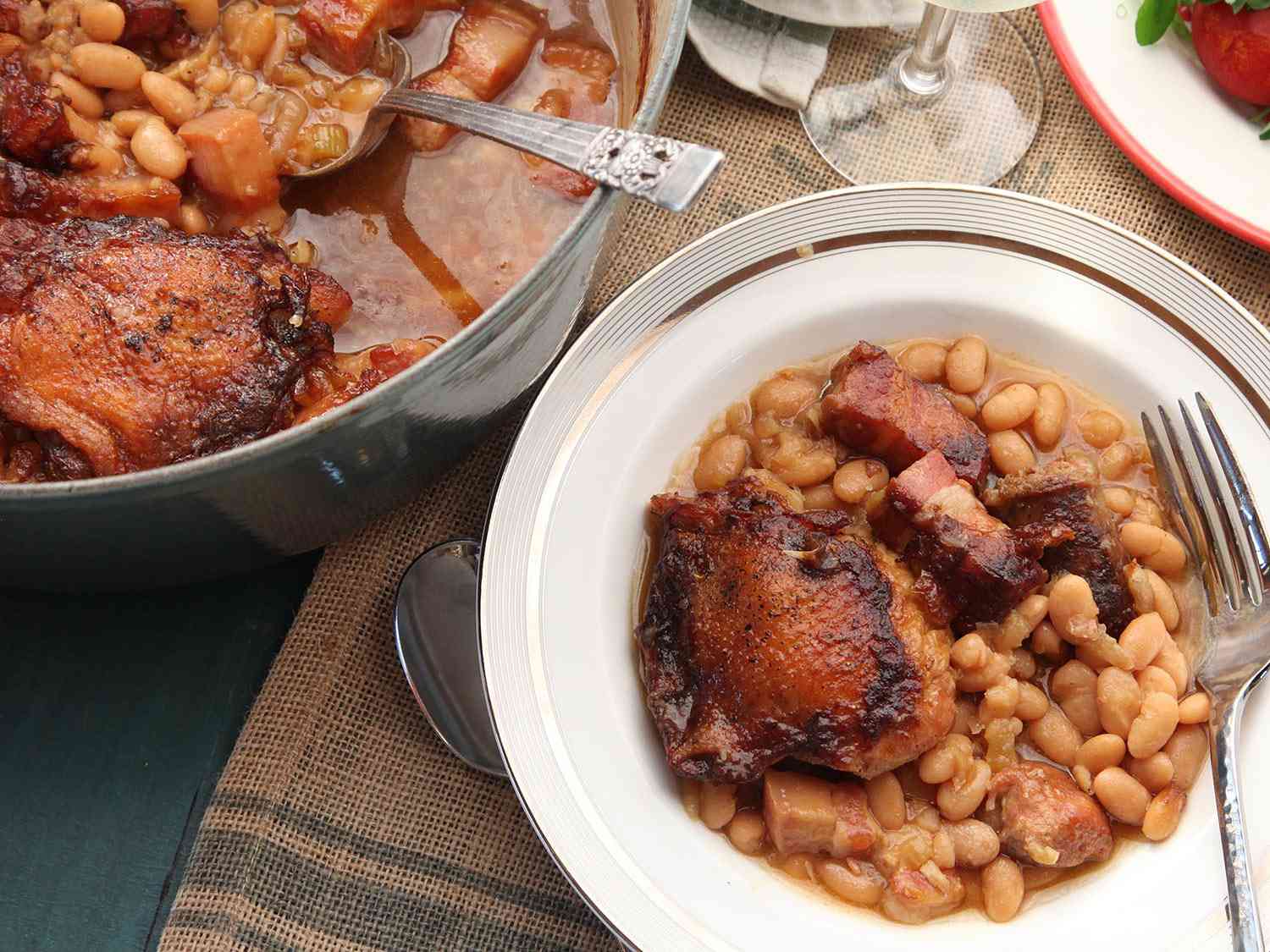 Cassoulet on a serving plate next to the Dutch oven it's baked in. 