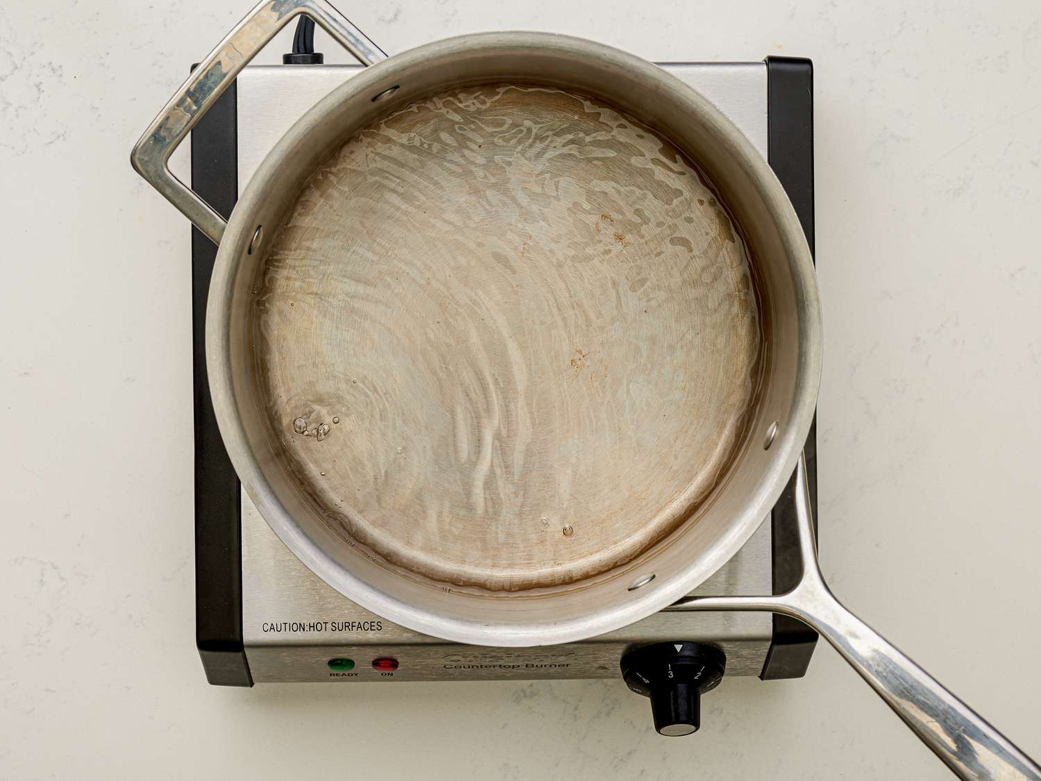 Overhead view of saucepan filled with water.