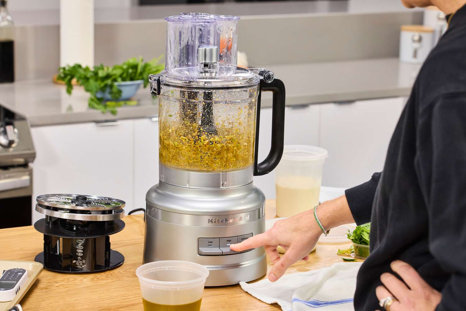 A person chops veggies in the KitchenAid 13-Cup Food Processor