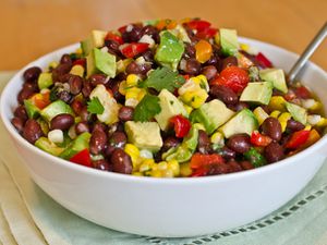 Black bean, corn, and red pepper salad in a white bowl with a fork.