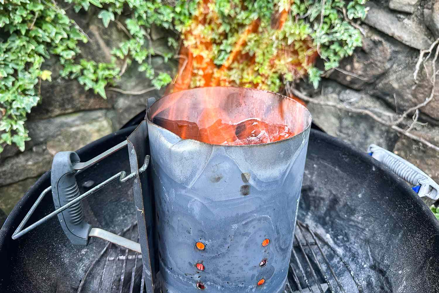 Jealous Devil Chunx Lump Charcoal briquettes being lit in a chimney starter on a barbecue grill