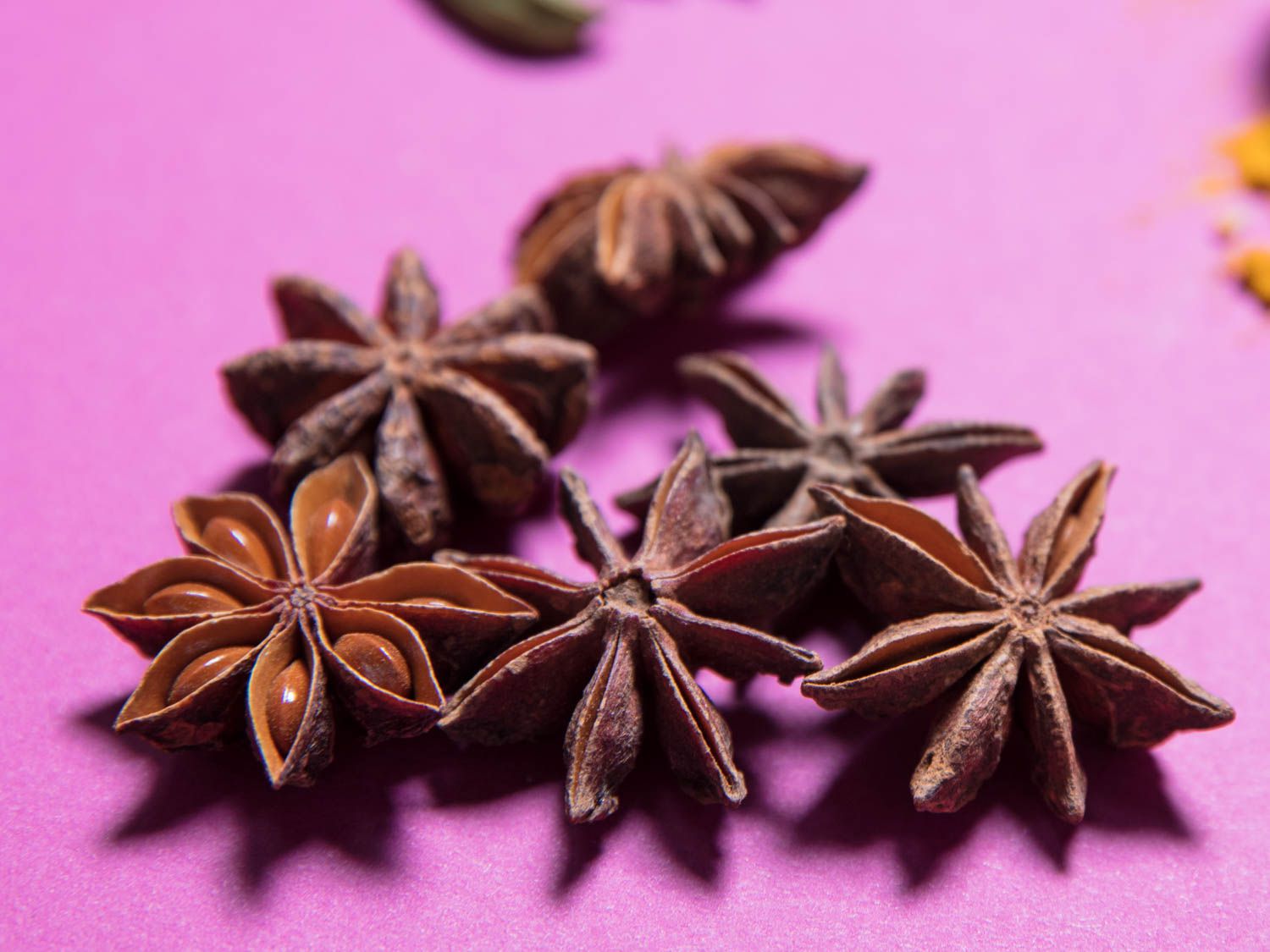 Star anise pods against a purple background